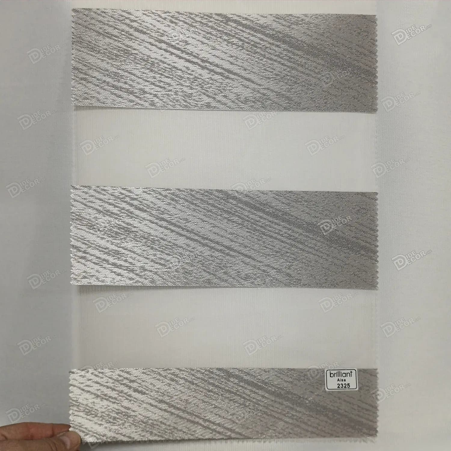 نمونه پارچه پرده زبرا کد T2325، طوسی براق با خطوط مورب طوسی تیره که با تغییر زاویه دید، رنگ پارچه تغییر می‌کند.