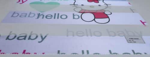 پرده زبرا کودک H-123-22 طرح دخترانه تصویر شخصیت کارتونی هلو کیتی با نوشته ی Hello Baby همراه قلب سبز و قرمز و زمینه سفید رنگ