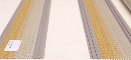 پرده زبرا خط دار کد S-306-8 با پارچه ترکیه ای که جنس پلی استر است تولید شده و زمینه آن رنگ های زرد و کرم با لبه های طوسی می باشد.